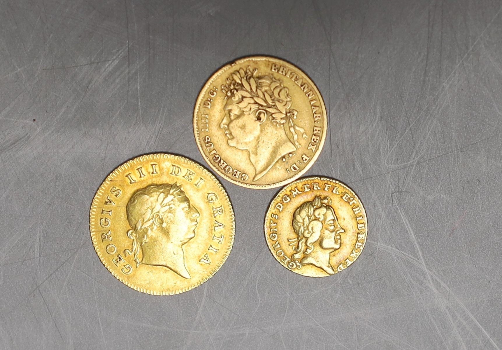 A George III half guinea 1806, good F, a George IV half sovereign 1825, about F, and a George I quarter guinea 1718, obv. struck off centre otherwise F